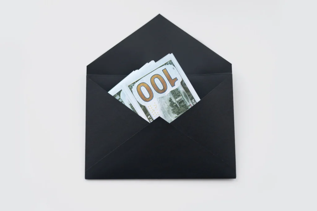 A black color envelop having Dollar notes in it 