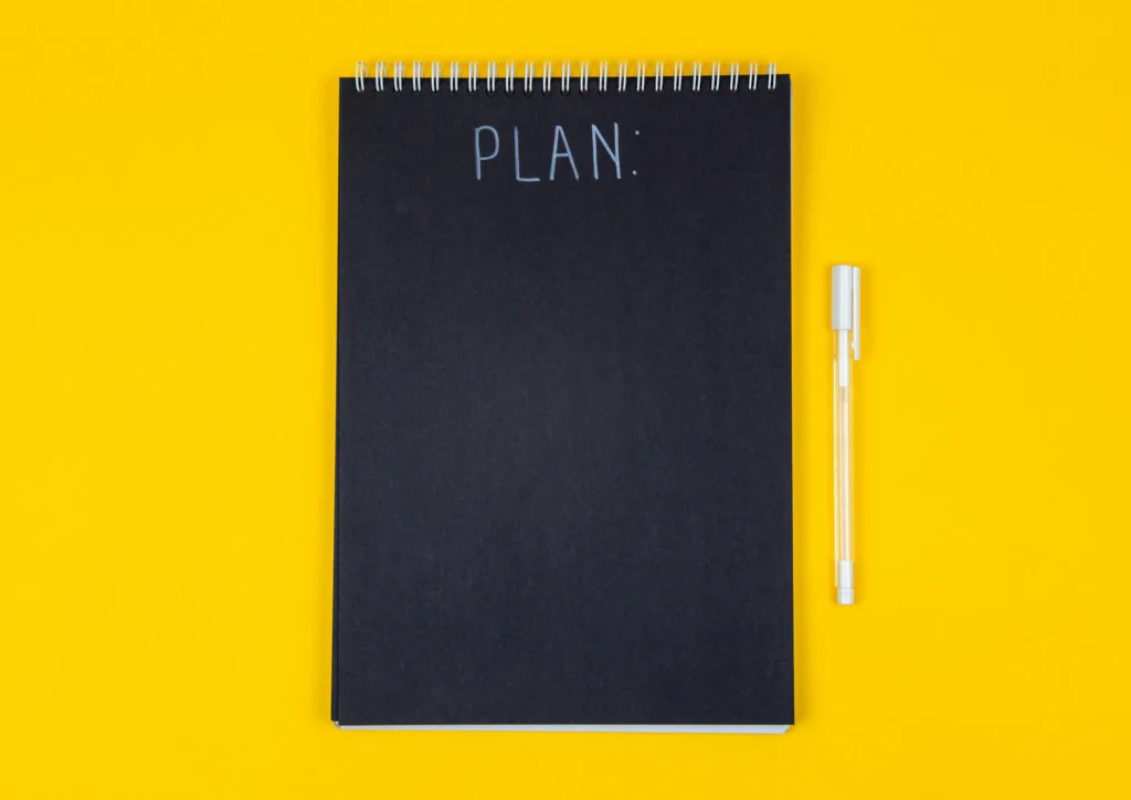 A pen and a notepad are placed and write a plan of your expenses and manage budget