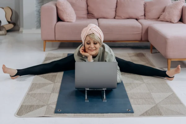 women doing yoga in front of laptop